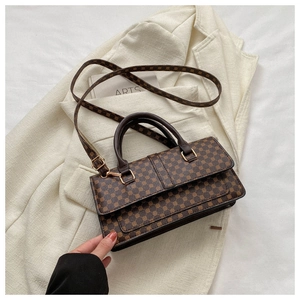Detail of dark brown retro crossbody bag with geometric texture on a white suit jacket