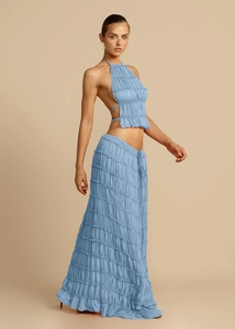 Detailed close-up of light blue tiered ruffle fabric and halter backless top design