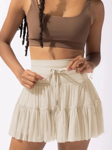 Detail of high-waist drawstring mesh pleated mini skirt with layered tulle texture