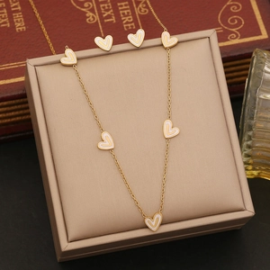 Parure cœur doré avec incrustation d'émail blanc sur collier et boucles d'oreilles