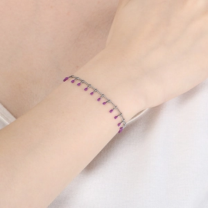 Detail shot of a silver titanium steel chain bracelet with purple drip oil pendants