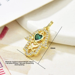 Detail of 18K gold plated Hamsa pendant with green heart zircon and white stone accents