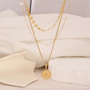 Multilayer gold chain necklace featuring white pearls and a round letter A coin pendant