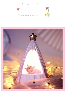 Close-up of cute pink angel night light with golden stars and glowing resin figure