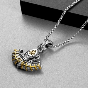 Close-up of vintage Viking axe pendant featuring silver Valknut symbol and golden accents