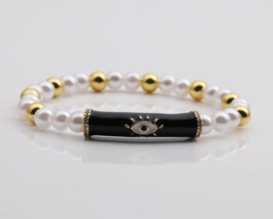 Detail of beaded Evil Eye bracelet with pearls, gold beads, and enamel charm