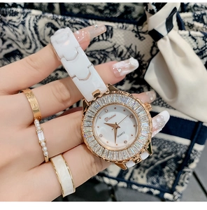 Elegant white ceramic watch with rose gold case and gemstone bezel on a model wrist