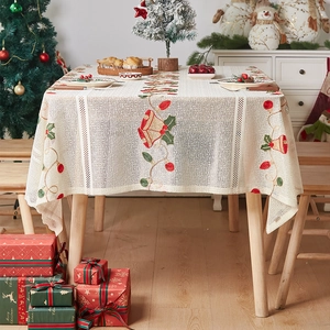 Detail of Christmas table runner with festive bells and holly on cream lace fabric