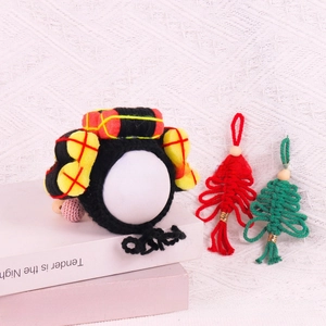Detailed close-up of handmade knitted pet headband with red and yellow festive decorations