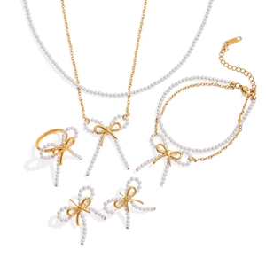 Elegant gold bow jewelry set with white pearls including necklace, bracelet, and earrings