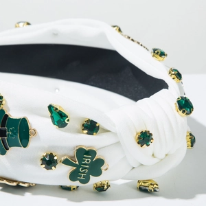 Detail of white St. Patrick's Day headband with green rhinestones and clover charms