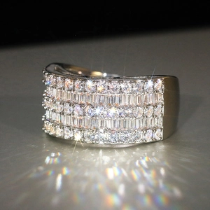 Close-up of wide silver ring with multi-row round and baguette cut sparkling cubic zirconia
