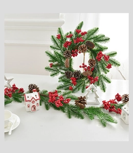 Nahaufnahme von Weihnachtskranz mit roten Beeren, Tannenzapfen und Nadeln in Heimdeko