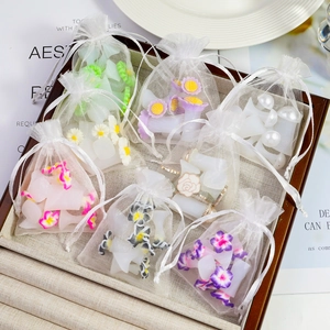 Detail of colorful daisy toe separators in mini white organza drawstring bags