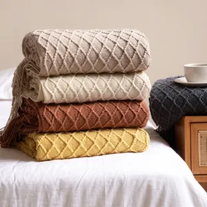 Detail of knitted throw blanket with fringe edges and classic diamond weave pattern