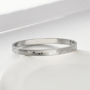 Dettaglio del bracciale in acciaio al titanio argento con incisioni a stella e fibbia