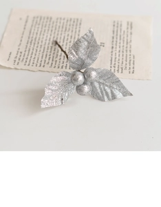 Sparkling silver glitter berry branch on vintage book page for Christmas tree decor