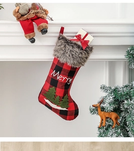 Chaussette de Noël à carreaux avec broderie Merry suspendue à une cheminée de fête