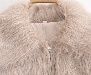 Close-up of soft beige faux fur collar and high-quality metal zipper on a cozy jacket