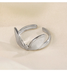 Close-up of silver adjustable ring with rabbit ear design on beige fabric background