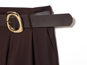 Detail of dark brown trousers with matching leather belt and oval gold metal buckle