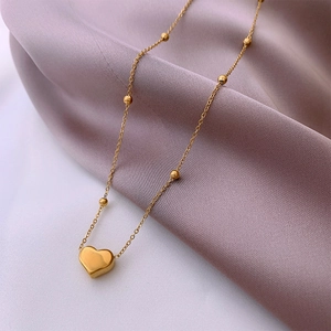 Polished titanium steel beaded necklace with a heart pendant on purple silk fabric