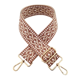 Detail of 5cm wide ethnic style woven bag strap with brown patterns and gold metal clips