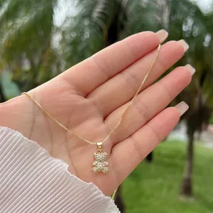 Close-up of a gold-plated bear pendant with shimmering white zircon stones on a chain