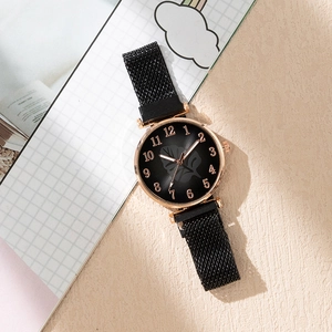 Detail of a ladies' black leaf pattern watch dial with rose gold case and magnetic strap