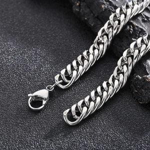 Macro shot of silver Cuban link chain with lobster clasp on dark textured background