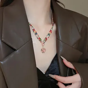 Colorful gemstone heart necklace with pink zircon pendant worn on professional suit outfit