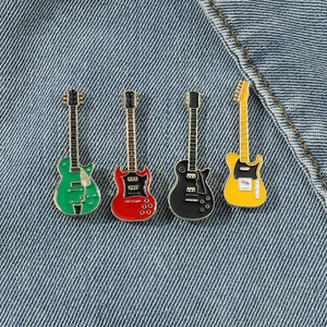 Set of four colorful enamel electric guitar pins on a textured blue denim background