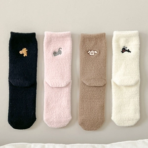 Detailed view of winter socks featuring delicate animal embroidery and plush coral fleece