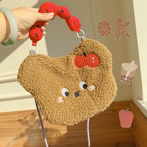 Close-up of brown plush bear crossbody bag with cute embroidery and red wavy handle