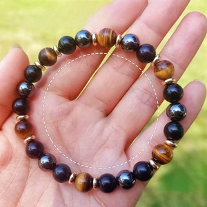 Tiger Eye and Black Obsidian 8mm bead stretch bracelet worn on wrist in a natural setting