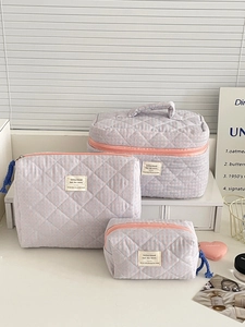 Quilted checkerboard cosmetic bag set with orange zipper and dark blue tassels details
