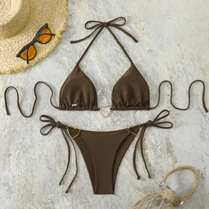 Detail of dark brown bikini featuring golden heart-shaped rings and side-tie design