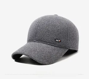 Detail of dark grey winter baseball cap featuring thick diagonal texture and sport badge