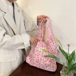 Close-up of pink floral quilted fabric bag with delicate floral pattern and branded label
