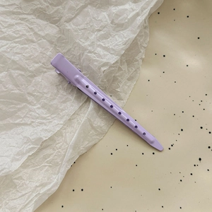 Macro detail of lavender matte metal hair clip with decorative hollow round holes