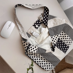 Detail shot of black and white polka dot canvas tote bag with inner pocket and snap closure