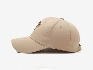 Vue détaillée latérale d'une casquette beige avec écusson brodé et texture en sergé de coton