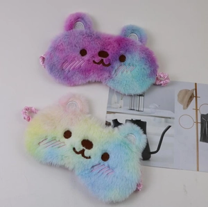 Detail of plush bear sleep masks with soft rainbow gradient faux fur and elastic straps