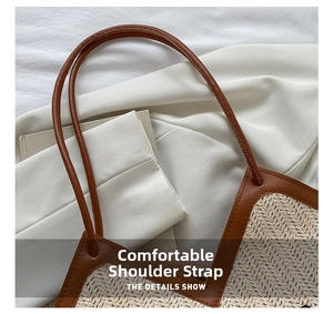 Close-up of beige woven straw tote bag with brown leather shoulder straps
