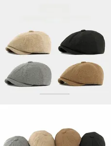 Detail view showing beige, black, grey, and camel knitted wool blend newsboy caps