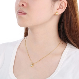 Elegant gold titanium steel necklace and earring set with white pearls on a model