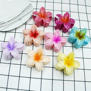 Detailed view of eight colorful gradient plumeria flower hair claws in candy colors