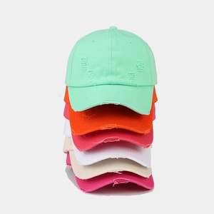 Vertical stack of multi-color distressed cotton baseball caps with ripped vintage details