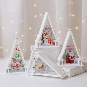 Close-up of a white Christmas lantern with festive illustrations and top hanging ring