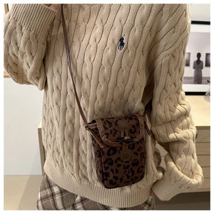 Detail of leopard print crossbody bag featuring soft plush texture and leather trim